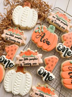 some decorated cookies are sitting on a cooling rack with pumpkins and one is for sale