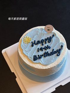 a blue frosted birthday cake with the words happy 1st birthday written in chinese on it