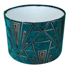 a blue lamp shade with an art deco design on it's side and black trim