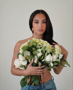 a woman holding a bouquet of flowers in her hands