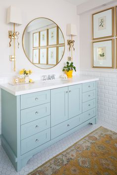 a bathroom with two sinks and mirrors on the wall next to a rug in front of it