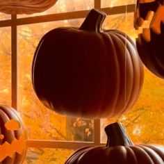 three pumpkins are hanging from the windowsill