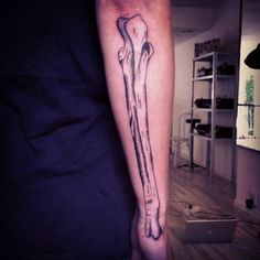 a person with a tattoo on their arm has a dog bone in the middle of it