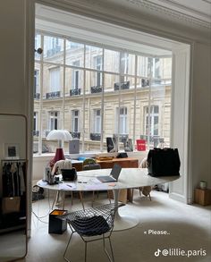 a room with lots of windows and furniture inside of it, including a table in front of the window