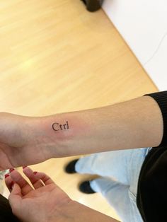 two people holding hands with small tattoos on their wrists and wrist, one has the word crt written on it