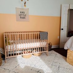 a baby's room with a crib, bed and rug on the floor