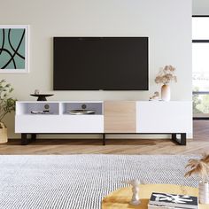 a living room with a large flat screen tv mounted on the wall next to a coffee table