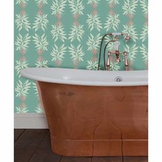 an old fashioned bathtub in front of a wallpapered background with green leaves