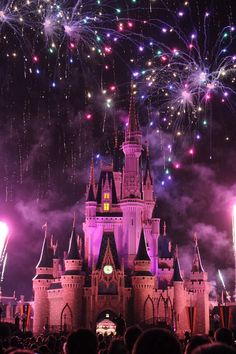 fireworks are lit up in the sky above a castle