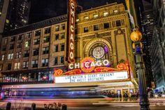 the chicago theater marquee lit up at night with traffic passing by in front