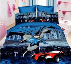 a bed room with a batman comforter and two red cars on the floor next to it