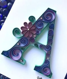 the letter a is made out of paper and has swirly designs on it's sides