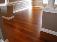 an empty room with hard wood flooring and white trim on the walls, along with windows