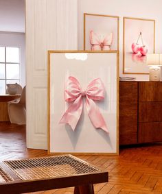 there is a pink bow on the wall next to pictures and a bench in front of it