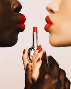 two women with red lipstick on their lips and one holding a silver object in her hand