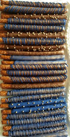 several blue and brown desserts are stacked on top of each other, with gold sprinkles