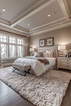 a large bed sitting in the middle of a bedroom on top of a white rug