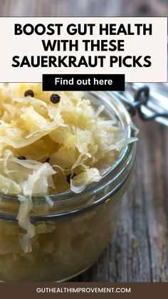 a glass jar filled with sauerkraut pickles on top of a wooden table