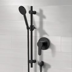 a black shower head and handset with thermostaer in front of white tiled wall