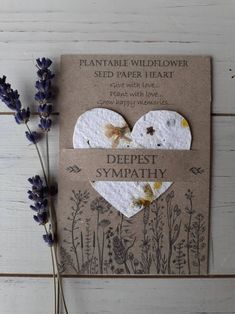 a card with two hearts on it next to some lavender flowers and a planter