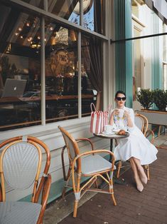 a woman sitting at an outdoor cafe table