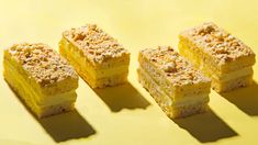 four pieces of cake sitting on top of a yellow countertop next to each other