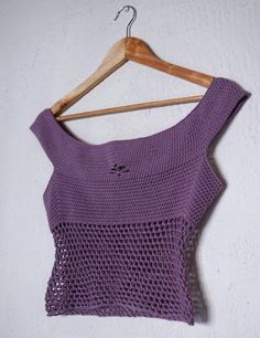 a purple crop top hanging on a wooden hanger