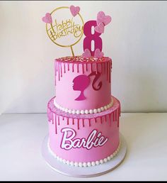 a birthday cake with pink icing and decorations