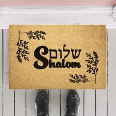 someone is standing in front of a door mat with the words shom on it