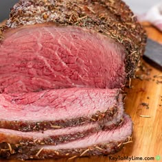 sliced roast beef sitting on top of a wooden cutting board