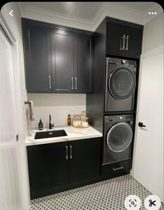 a kitchen with black cabinets and white counter tops, including a washer and dryer