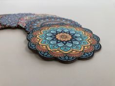 four coasters with designs on them sitting on a table