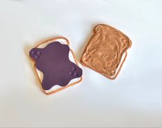 two peanut butter and jelly sandwiches on a white table with a cup of coffee in the background