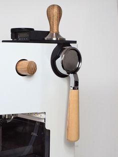 a kitchen appliance mounted to the side of a wall with a wooden spatula