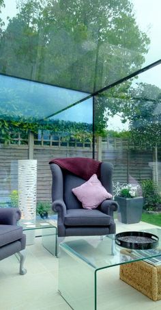 a living room filled with furniture next to a glass wall