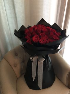 a bouquet of red roses sitting on top of a chair