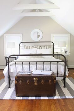 a suitcase sitting on top of a bed next to a wooden floor in a bedroom