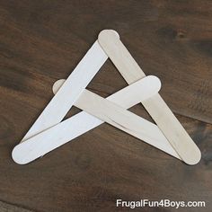 a wooden stick with three intersecting pieces cut out of it sitting on top of a table