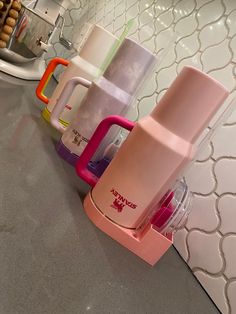 the blender is sitting on the counter next to other cups and mixers that are lined up behind it