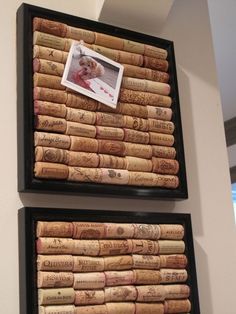 two framed pictures are stacked on top of wine corks and the bottom one has an image of a baby in it