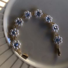 a white plate topped with a blue and gold beaded bracelet