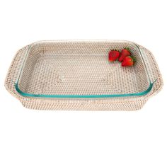 two strawberries sitting on top of a wicker serving tray with glass sides and handles