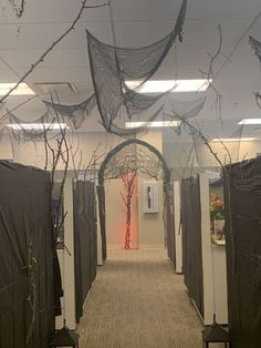 the hallway is decorated with halloween decorations and netted trees in front of doors that lead into an office building