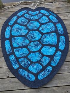 a blue heart shaped rug sitting on top of a wooden floor next to a fence