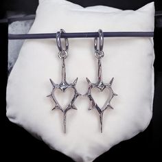 Gothic Thorn Heart Earrings - Korean Punk Charms for Women, Hip Hop Grunge Jewelry 📦 Processing Time: 5-7 days ✈ Shipping Time: 6-10 days Shipping: Free international shipping on all orders! Customer Satisfaction Guaranteed: If your earrings arrive damaged, we offer a full refund or replacement. Add a touch of rebellion to your jewelry collection with these striking Gothic Thorn Heart Earrings. Perfect for yourself or as a gift for someone who loves bold, alternative fashion! Questions? Feel fr Edgy Hoop Earrings As A Gift, Edgy Pierced Earrings For Concerts, Punk Metal Earrings For Concerts, Punk Style Metal Earrings For Concert, Grunge Style Earrings For Pierced Ears As Gift, Silver Punk Earrings For Concert, Edgy Heart-shaped Jewelry For Alternative Fashion, Punk Style Earrings For Concert, Heart-shaped Punk Jewelry For Concerts