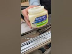 a person holding a jar of mayonnaise in their hand