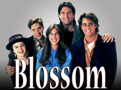 a group of people standing next to each other in front of a sign that says blossom