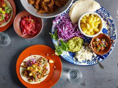 mexican food is served on colorful plates and bowls