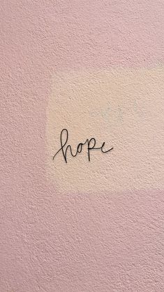 the word hope written in black ink on a pink wall