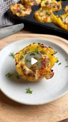 a white plate topped with food on top of a wooden cutting board